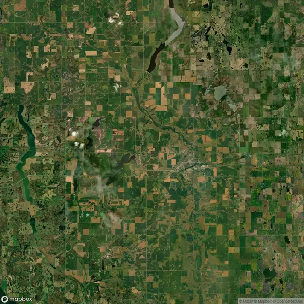 Aerial view of a rural landscape featuring patchwork fields, rivers, and scattered clouds.