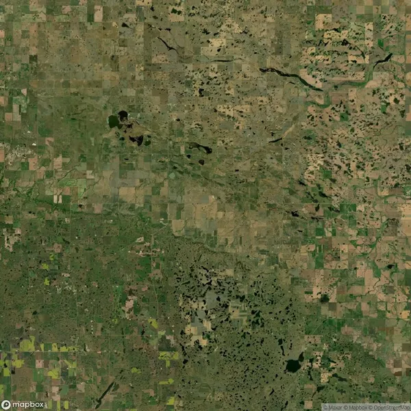 Aerial view of a landscape showing a patchwork of agricultural fields, grasslands, and scattered water bodies.