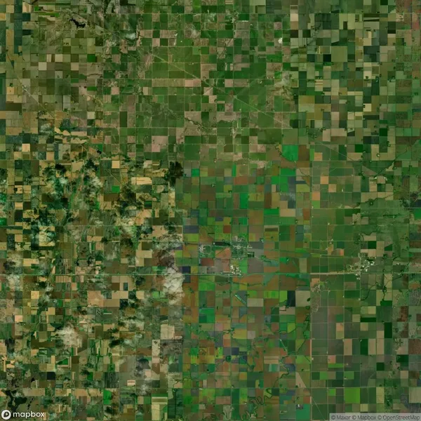 Satellite view of a landscape with a patchwork of green and brown agricultural fields, featuring a grid-like pattern of roads or boundaries.
