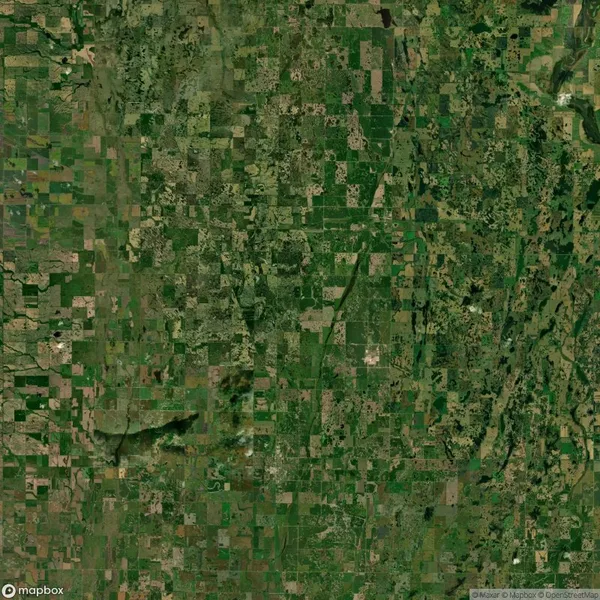 A satellite view showing a patchwork of agricultural fields and green landscapes, with visible roads and some scattered wooded areas.