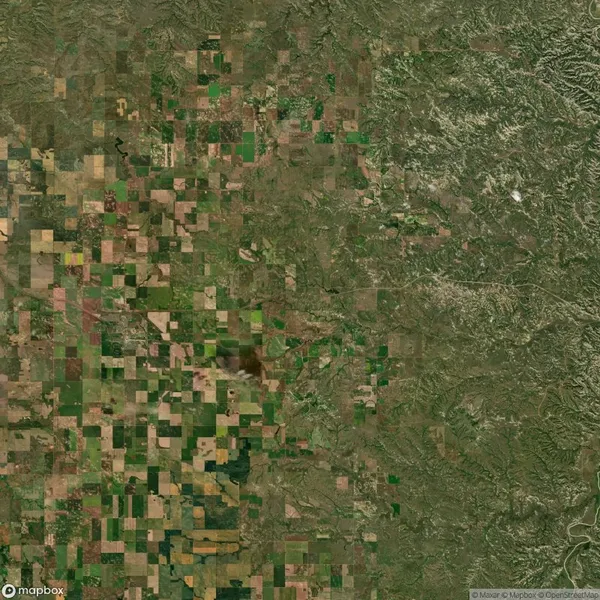 Aerial view of a landscape with a patchwork of agricultural fields and natural terrain.