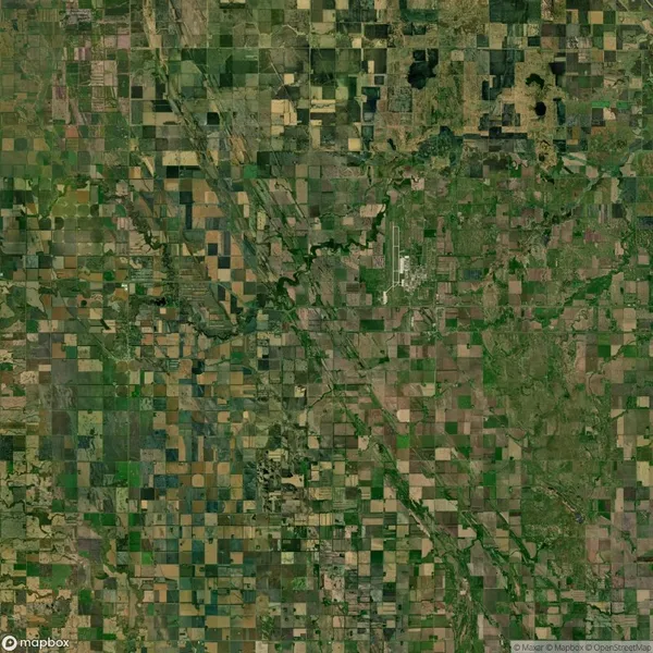 Aerial view of a vast patchwork of agricultural fields and green landscapes divided by roads.