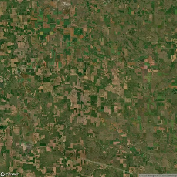 Aerial view of a patchwork landscape composed of various rectangular fields in differing shades of green and brown.