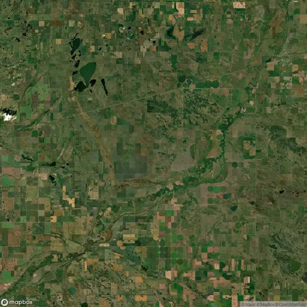 Aerial view of a patchwork landscape with fields, rivers, and scattered ponds, displaying various shades of green and brown.