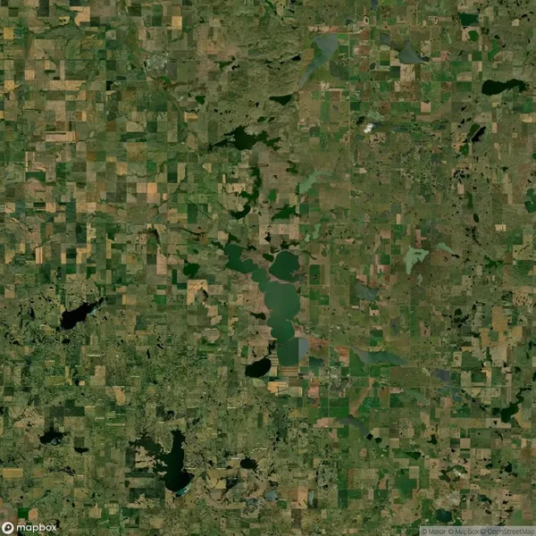 Aerial view of a green landscape with lakes and square agricultural fields scattered throughout.