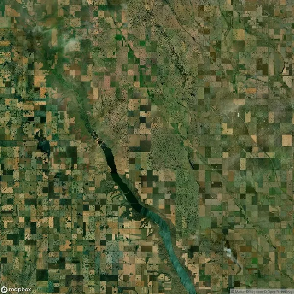 Aerial view of a rural landscape with a patchwork of agricultural fields and a river winding through the center.