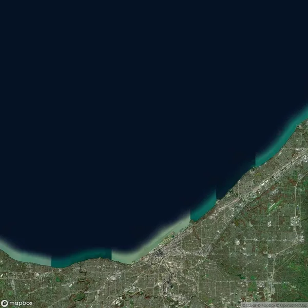 Satellite image of a coastal city with a body of water to the north and urban areas along the shoreline.