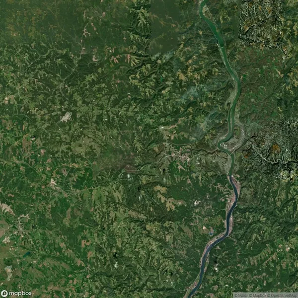 Satellite image of a green landscape showing a winding river running from the bottom center to the top right. Various shades of green indicate forested and vegetated areas.