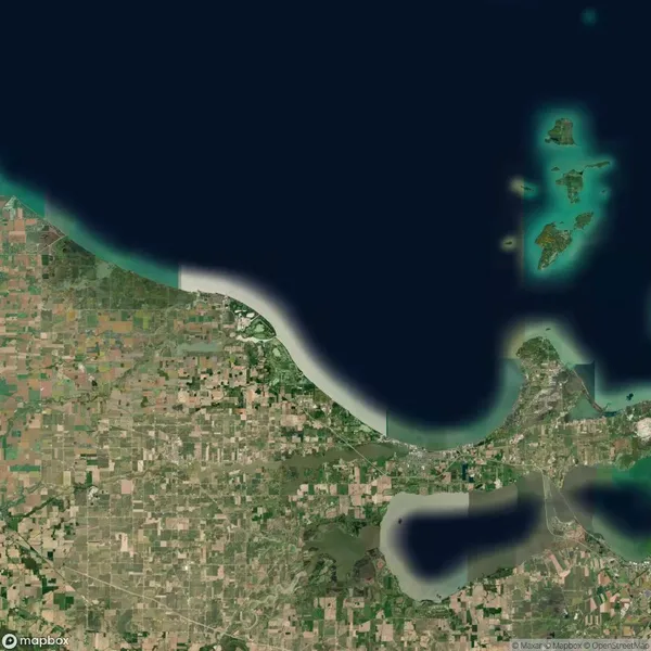 Satellite view of a coastal region with agricultural fields bordering a large body of water. Small islands are visible in the upper right.