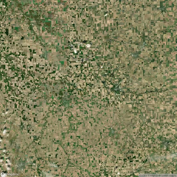 Aerial view of a patchwork landscape with irregular green and brown farmland plots.