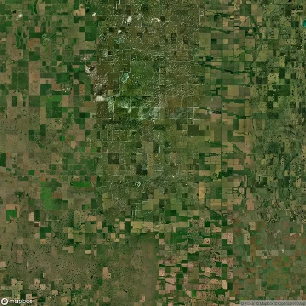 Aerial view of a large landscape with a grid pattern of agricultural fields. The fields vary in shades of green and brown, indicating different crops or stages of growth.
