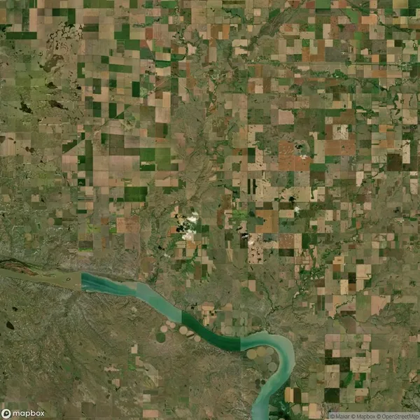 Aerial view of a patchwork of agricultural fields and a winding river in a rural landscape.