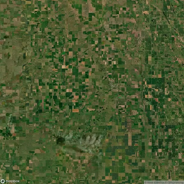 Satellite view showing a patchwork of agricultural fields and greenery spread across a landscape.
