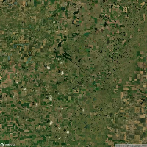 Aerial view of a patchwork landscape with farmland, fields, and scattered bodies of water.