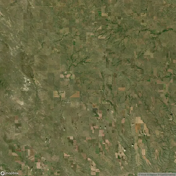 Aerial view of a patchwork landscape with various shades of green and brown, showcasing fields, vegetation, and natural terrain patterns.