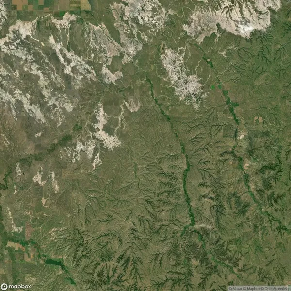 Satellite view of a green and brown landscape featuring winding rivers and a patchwork of agricultural fields in the top left corner.