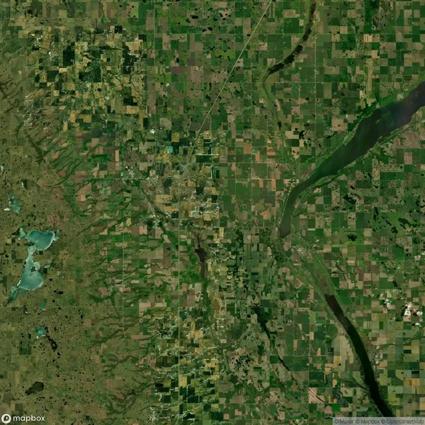 Satellite view of a rural landscape with rectangular agricultural fields, a large river on the right, and a smaller body of water on the left.