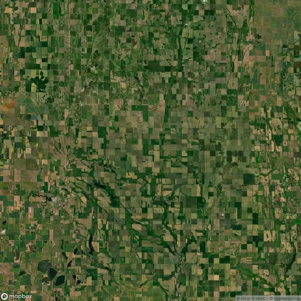 Aerial view of a landscape with patchwork fields and scattered waterways, displaying a mix of farmland and vegetation.