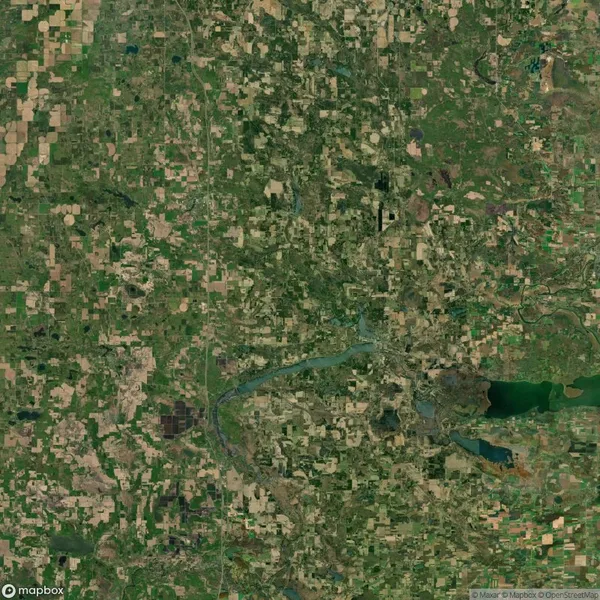 Satellite image of a landscape with a river winding through fields and patches of forest. A lake is visible in the bottom right corner. Roads and small settlements dot the area.
