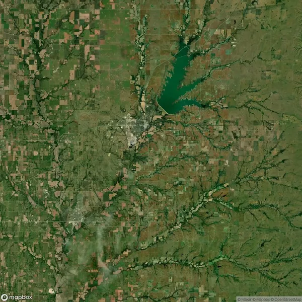Satellite view of a rural area with farmland, small towns, a large lake near the center top, and branching waterways and green patches throughout.