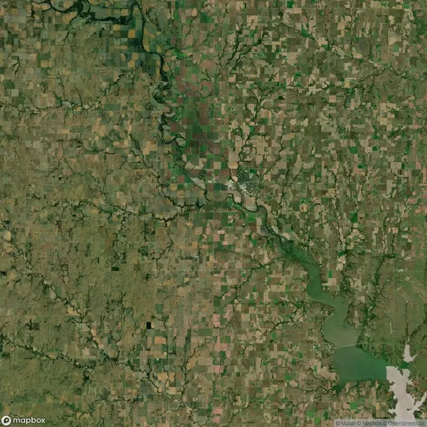 A satellite view of a rural landscape shows a patchwork of agricultural fields, intersected by winding rivers and bordered by a large reservoir in the bottom right corner.