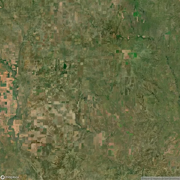 Aerial satellite view of a rural landscape featuring patchwork farmland, fields, and areas of greenery.