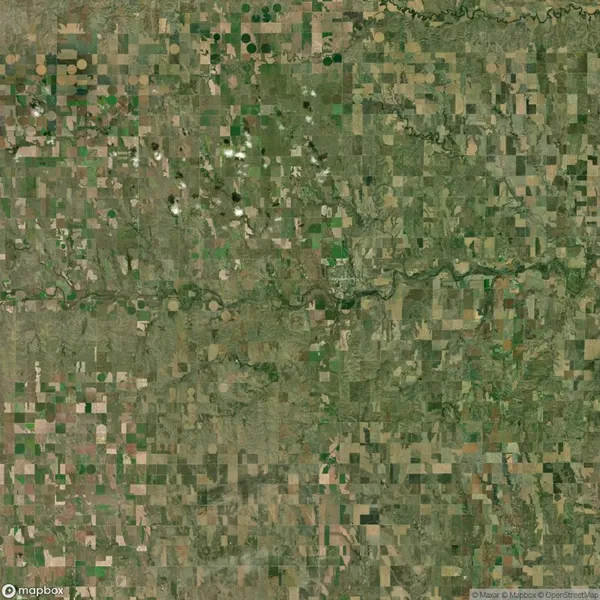 Aerial view of a rural landscape with patchwork agricultural fields, a winding river, and scattered clouds.
