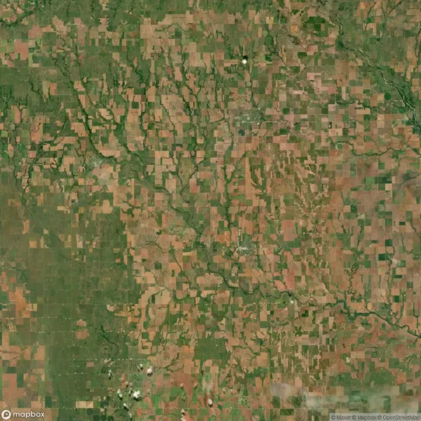 Aerial view of a rural landscape featuring a patchwork of agricultural fields, intersected by winding rivers and scattered patches of forest.