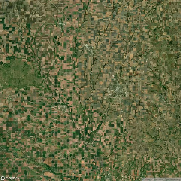 Aerial view of a rural landscape with a grid-like pattern of agricultural fields, patches of green vegetation, and winding rivers.
