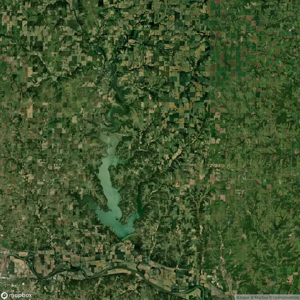 Satellite image shows a winding lake surrounded by irregular patches of farmland and forested areas, with a river running horizontally near the bottom of the image.