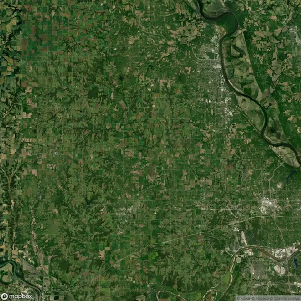 Aerial satellite view of a large, green, patchwork landscape with farmland, roads, and a winding river on the right side of the image.