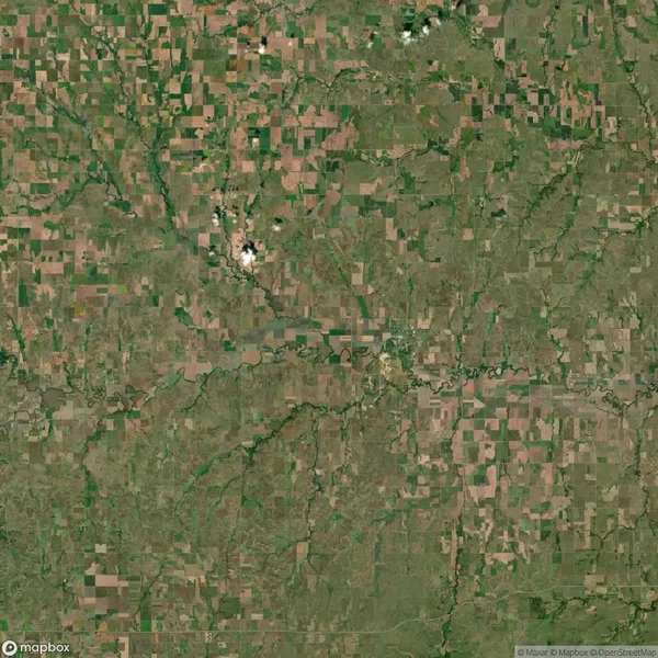 Aerial view of a rural landscape with patchwork farmland, scattered small forests, rivers, and streams.