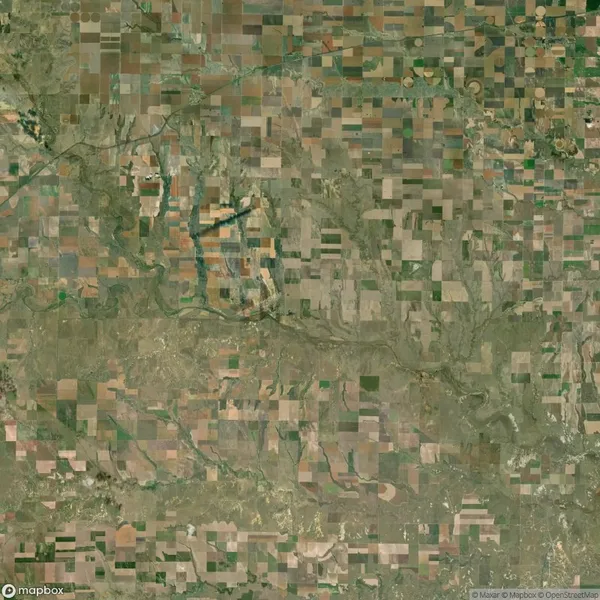 Aerial view of a rural landscape with a patchwork of rectangular agricultural fields and winding rivers.