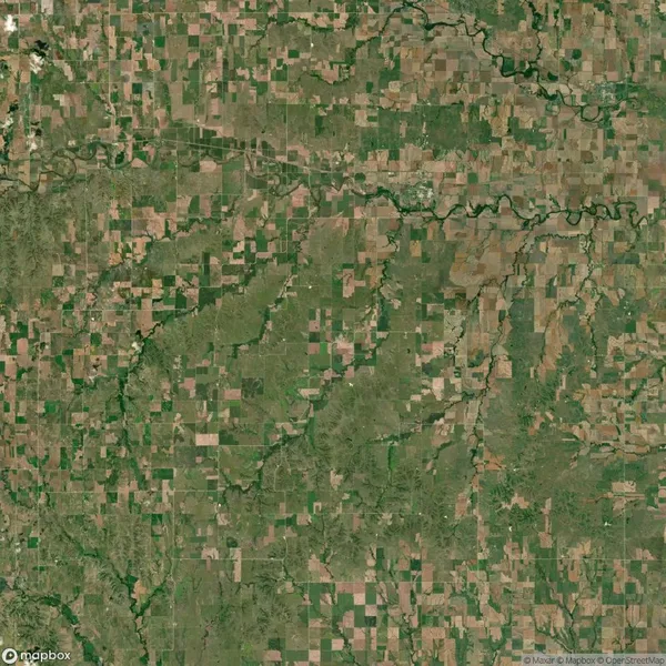Aerial view of a rural landscape with a patchwork of green and brown agricultural fields, winding rivers, and scattered clusters of trees.