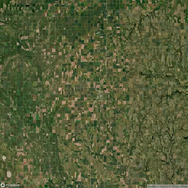 Aerial view of a rural landscape with a patchwork of agricultural fields and irregular terrain on the right side.