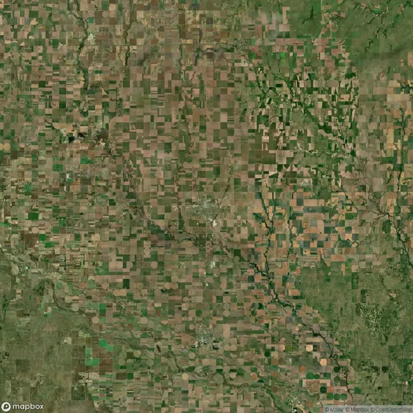 Aerial view of a patchwork landscape featuring numerous rectangular agricultural fields separated by irregular rivers and patches of green vegetation.