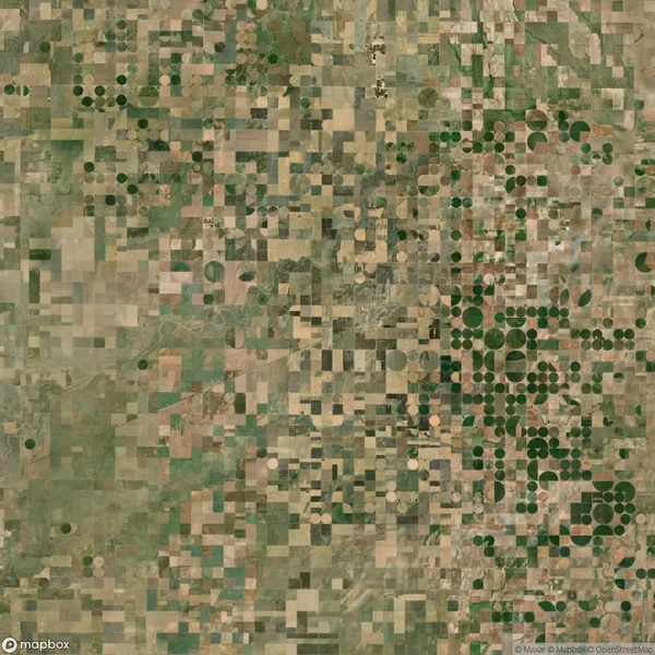 Aerial view of farmland featuring a patchwork of rectangular fields and circular crop patterns, illustrating different irrigation and farming techniques.