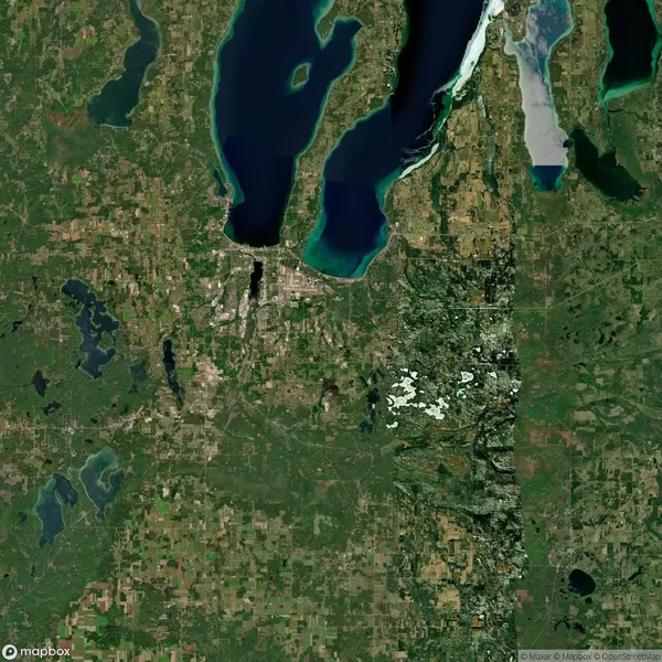 A satellite view of a landscape featuring lakes, rivers, and mixed farmland and forest, with large bodies of water in the upper part of the image.