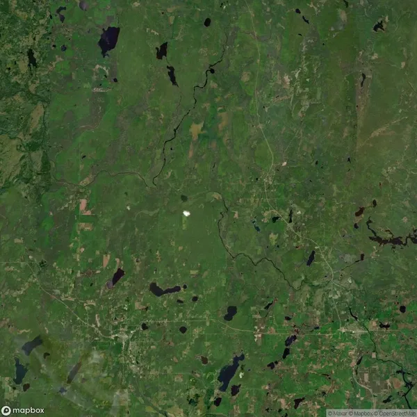Satellite view of a green, rural landscape with scattered lakes, rivers, roads, and patches of forest and farmland.