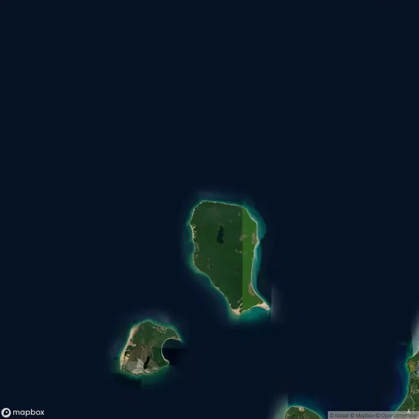 Satellite view of three green islands surrounded by dark blue ocean; the largest island is in the center, with two smaller islands below it.
