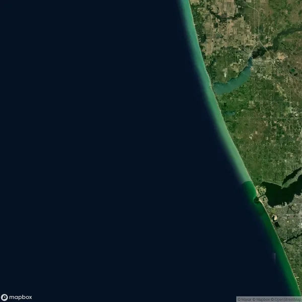 Satellite view of Florida’s east coast showing the Atlantic Ocean on the left and a mix of urban and green land areas on the right.
