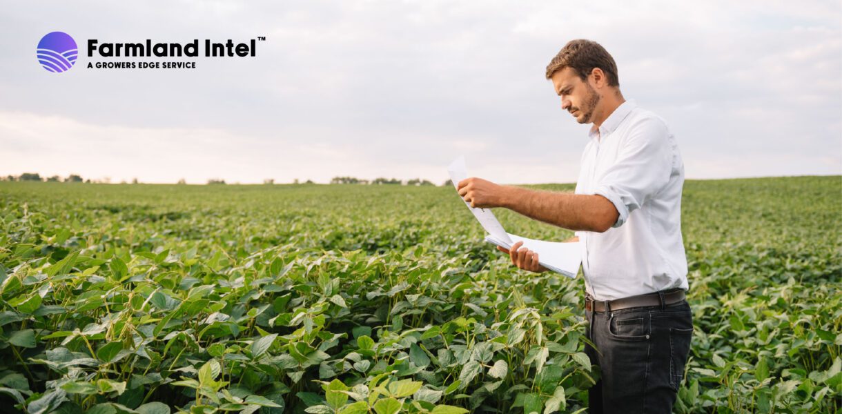 A man in a white shirt stands in a green crop field, examining papers. The "Farmland Intel" logo appears in the upper left corner.
